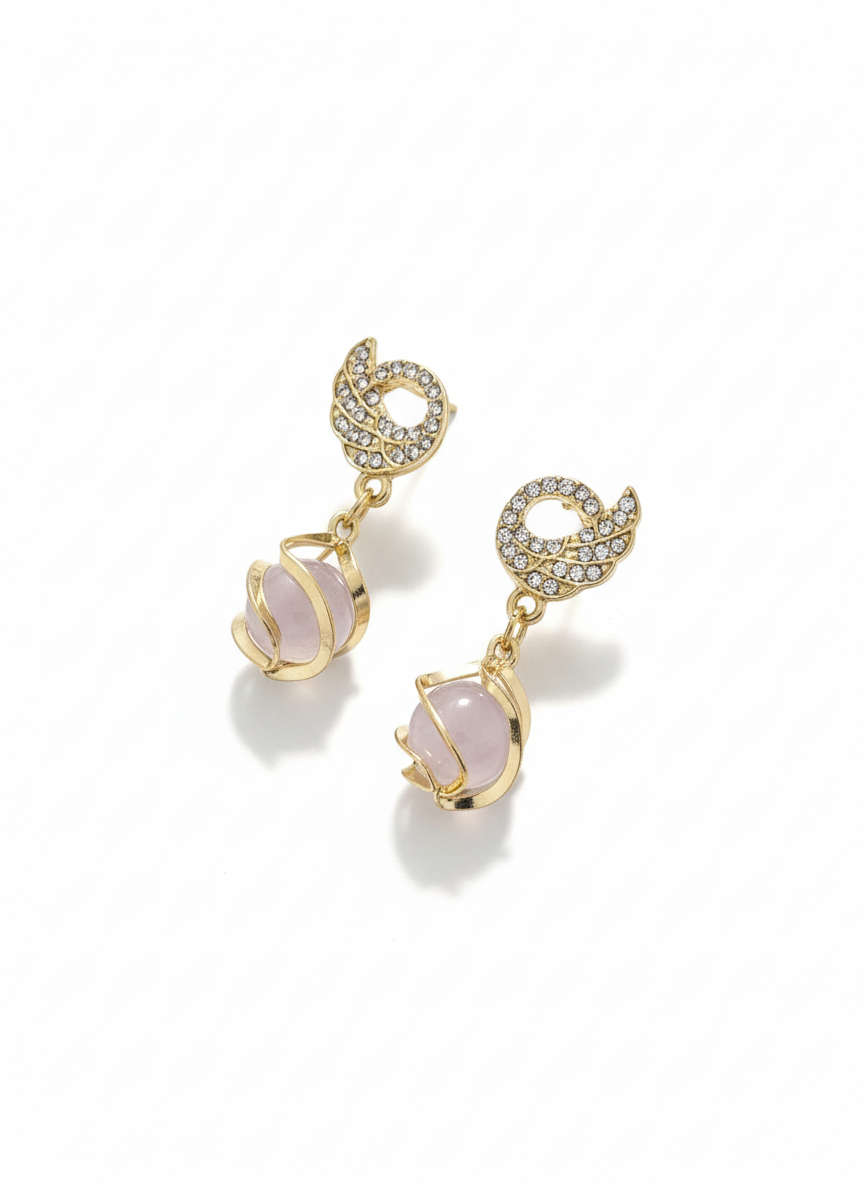 Gold earrings with pink gemstones on a white background