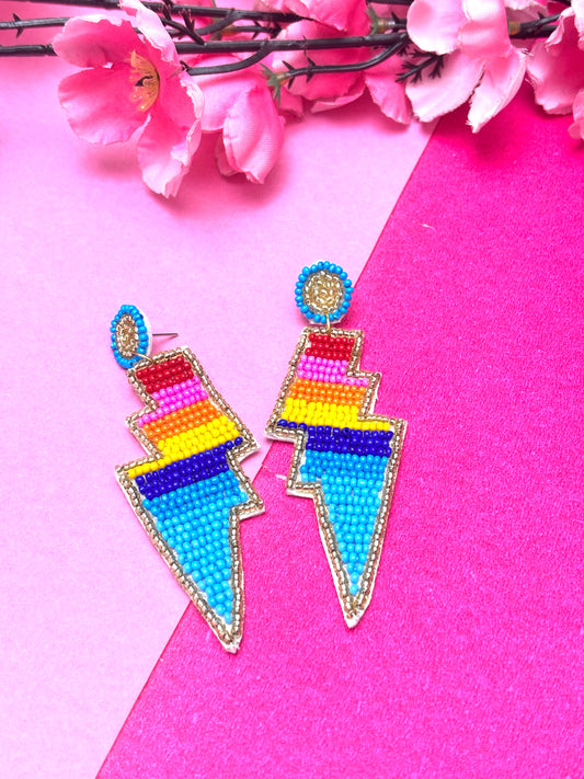 Colorful beaded earrings on a pink background with flowers