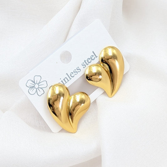 Gold heart-shaped earrings on a white card with 'ainless steel' text.