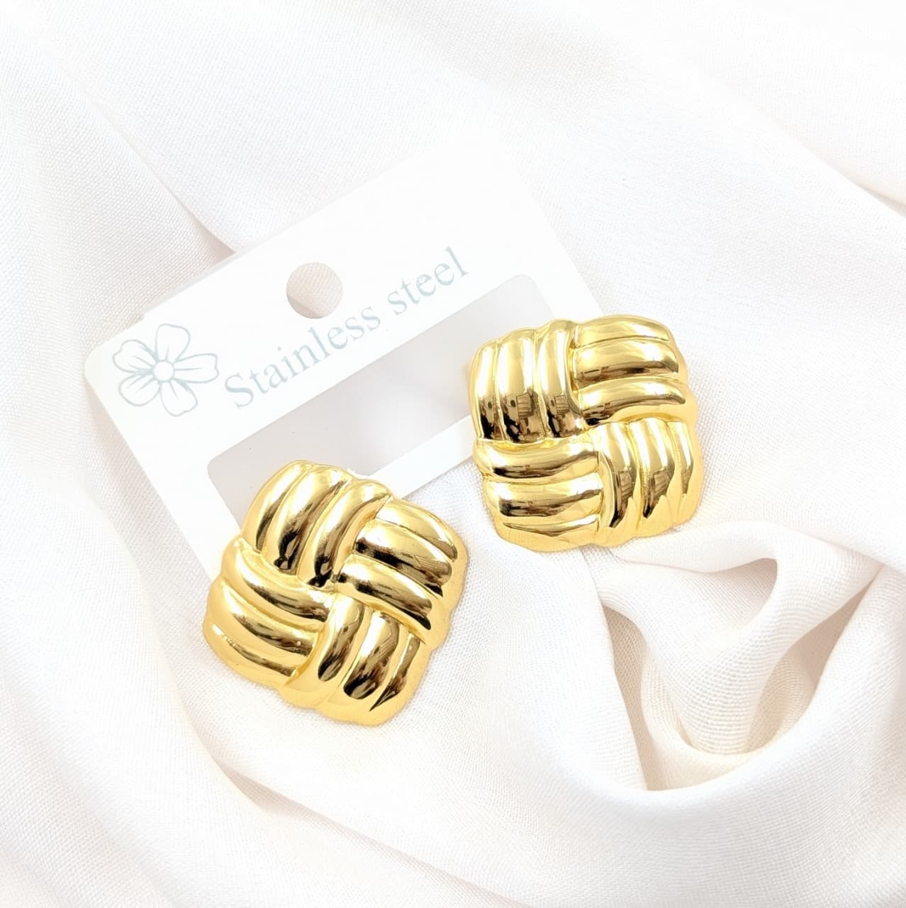 Gold knot earrings on a white card with 'Stainless Steel' text